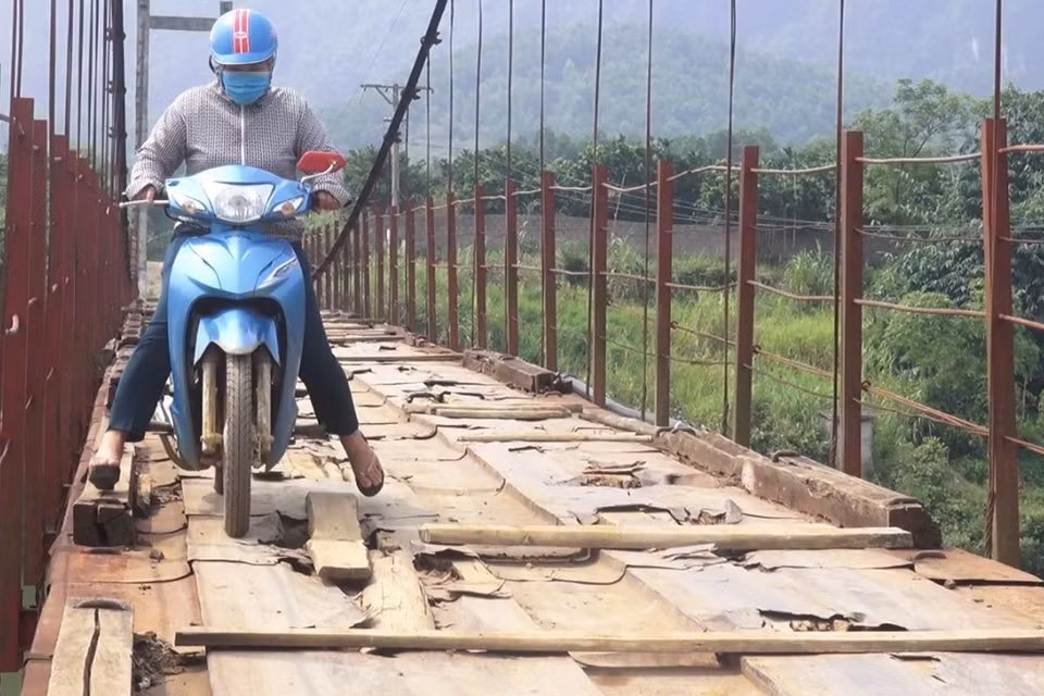 Người dân lưu thông khó khăn trên cầu treo xuống cấp. (Ảnh: Thanh Hải/TTXVN)