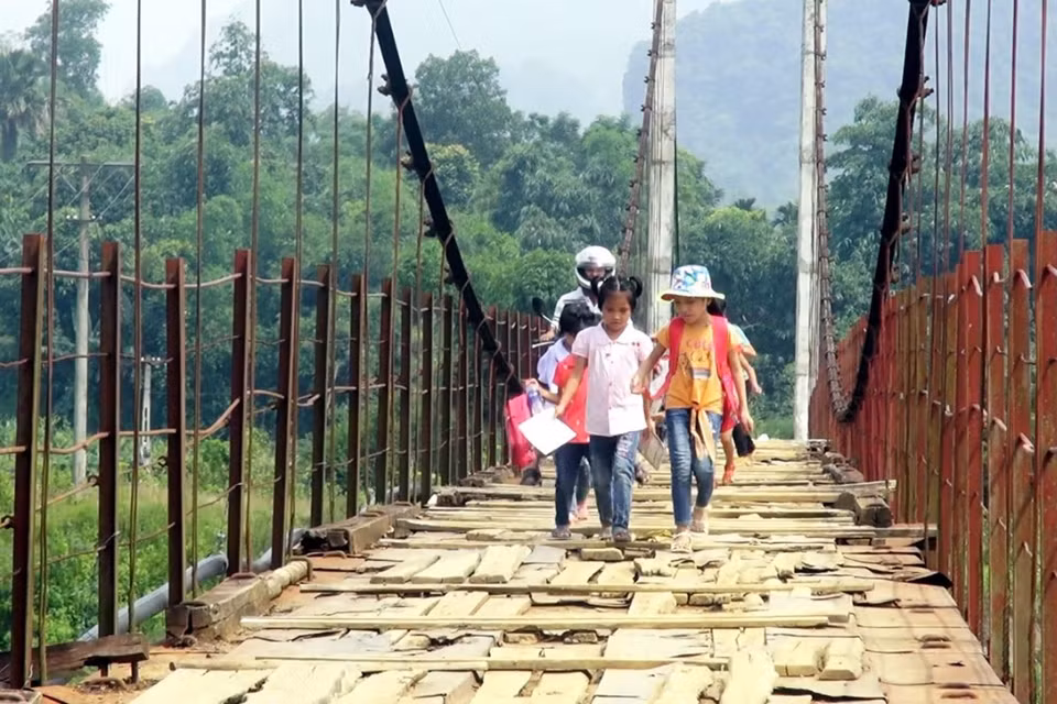 Học sinh lo sợ khi đi trên cầu treo xuống cấp. (Ảnh: Thanh Hải/TTXVN)