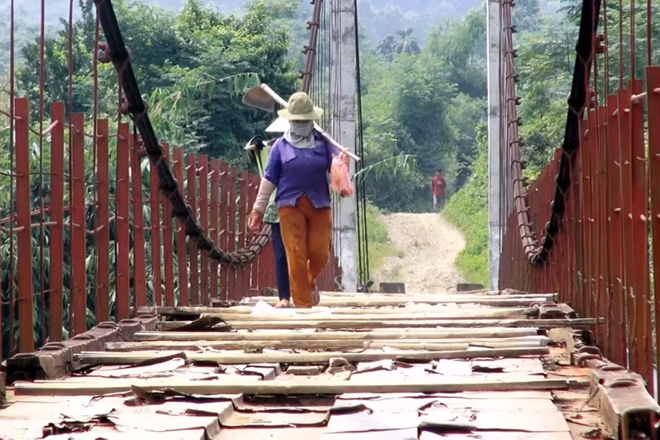 Người dân lưu thông khó khăn trên cầu treo xuống cấp. (Ảnh: Thanh Hải/TTXVN)