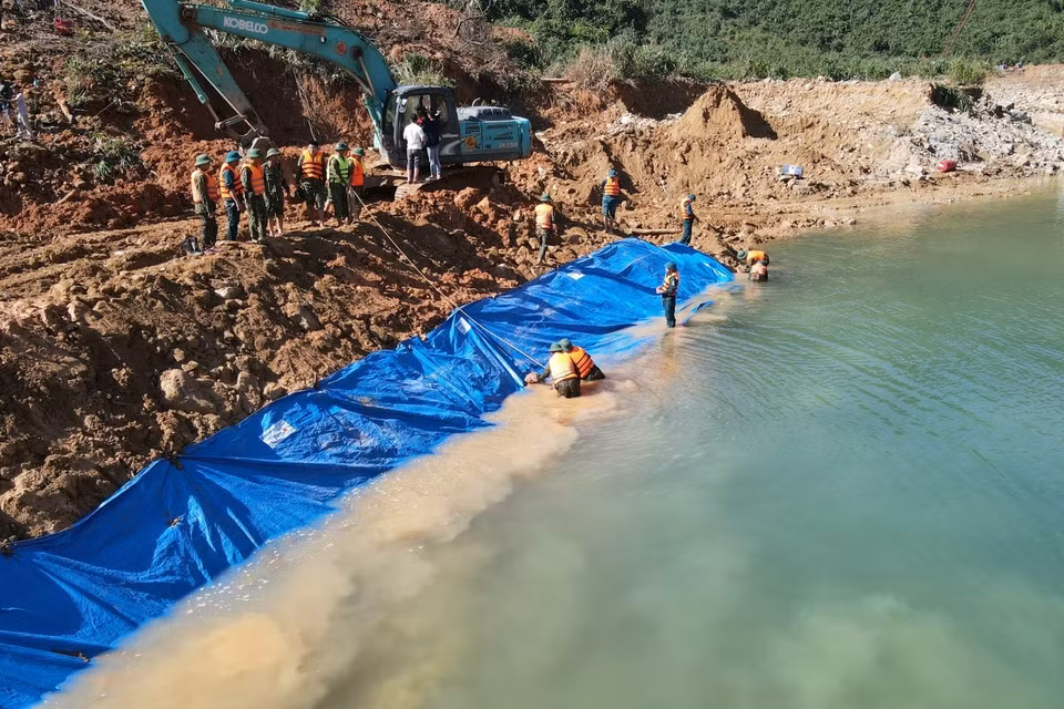 Lực lượng chức năng nắm dòng chảy mới được tạo nên để phục vụ công tác tìm kiếm dưới lòng suối Rào Trăng. (Ảnh: TTXVN phát)