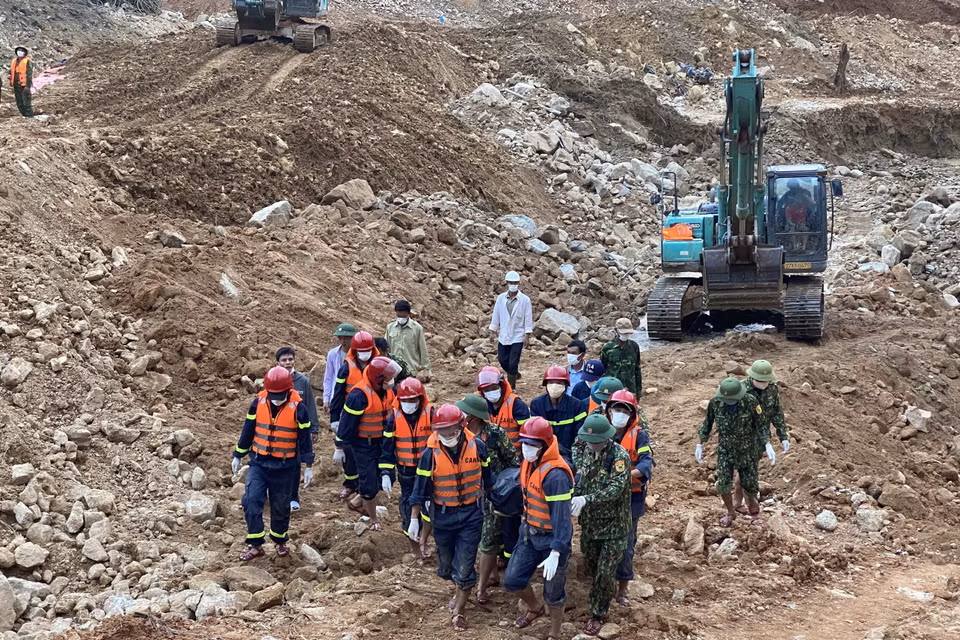 Lực lượng chức năng đưa thi thể nạn nhân ra khỏi hiện trường. (Ảnh: TTXVN phát)