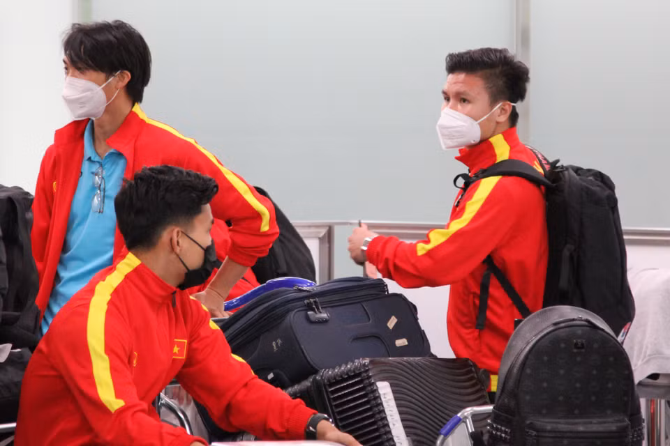 Các tiền vệ Quang Hải và Tuấn Anh đang chờ lên xe buýt ở sân bay. (Ảnh: Đào Thanh Tùng/TTXVN)