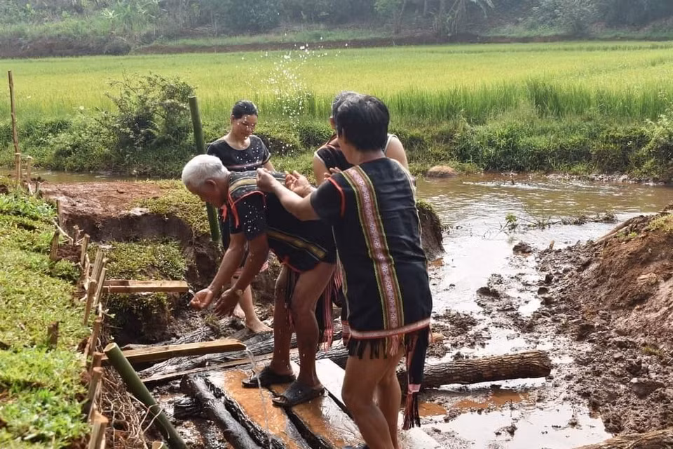 Sau lễ cúng, người dân trong làng cùng xuống giọt nước để thực hiện các nghi thức cầu may mắn. (Ảnh: TTXVN phát)
