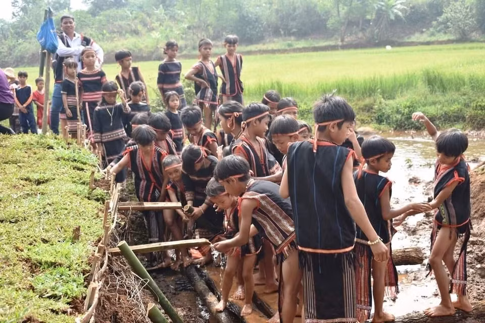 Sau lễ cúng, người dân trong làng cùng xuống giọt nước để thực hiện các nghi thức cầu may mắn. (Ảnh: TTXVN phát)