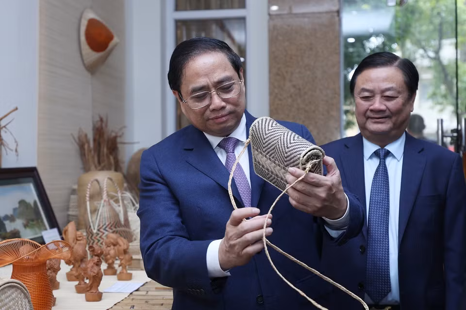 Hình ảnh Thủ tướng Phạm Minh Chính xem trưng bày sản phẩm nông nghiệp, thủ công mỹ nghệ. (Ảnh: Dương Giang/TTXVN)
