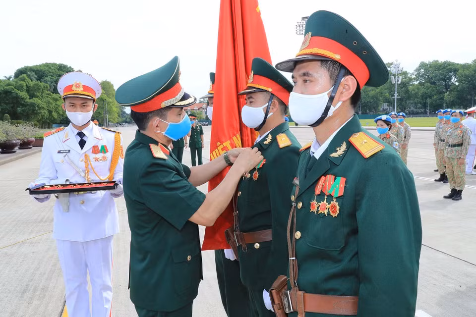 Tặng Huy hiệu Bác Hồ cho các sỹ quan của Bệnh viện dã chiến cấp 2 số 2 và sỹ quan hoạt động độc lập tại lễ báo công. (Ảnh: Trọng Đức/TTXVN)