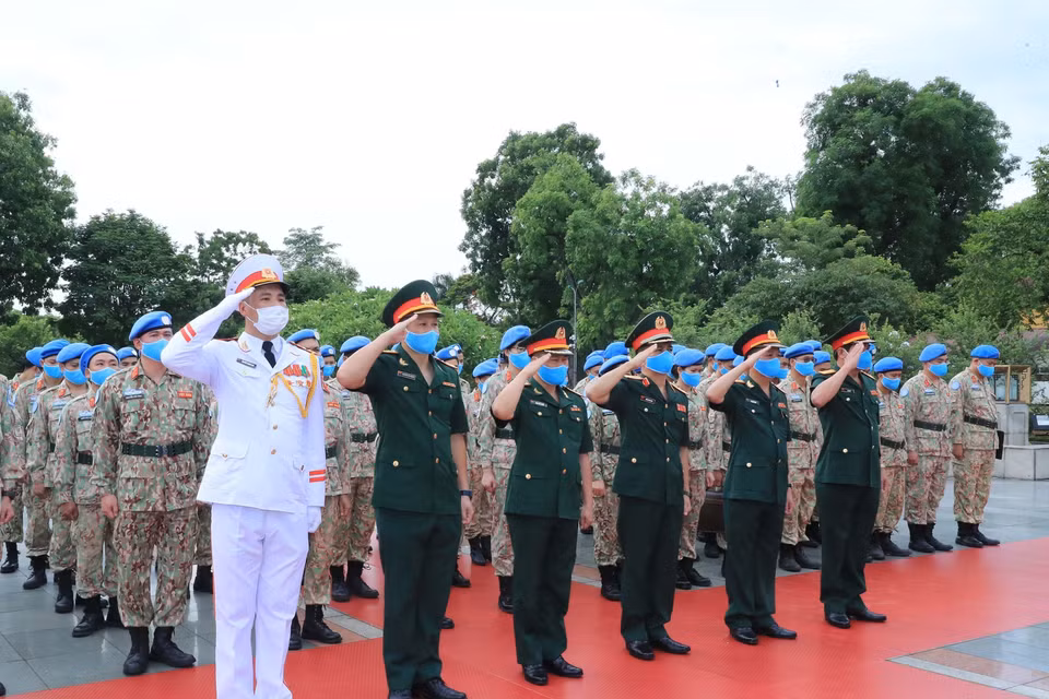 Các sỹ quan của Bệnh viện dã chiến cấp 2 số 2 và làm nhiệm vụ gìn giữ hòa bình Liên hợp quốc tưởng niệm tại Đài tưởng niệm các Anh hùng liệt sĩ trên đường Bắc Sơn. (Ảnh: Trọng Đức/TTXVN)