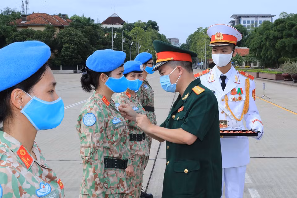 Tặng Huy hiệu Bác Hồ cho các sỹ quan của Bệnh viện dã chiến cấp 2 số 2 và sỹ quan hoạt động độc lập tại lễ báo công. (Ảnh: Trọng Đức/TTXVN)