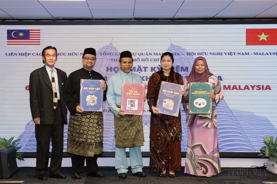 Tổng lãnh sự Wong Chia Chiann và các nhân viên Tổng lãnh sự quán Malaysia tại TP Hồ Chí Minh nhận sách giới thiệu về Tết truyền thống Việt Nam tại buổi họp mặt kỷ niệm lần thứ 65 ngày Quốc khánh Malaysia, ngày 9/9/2022. (Ảnh: Xuân Khu/TTXVN)
