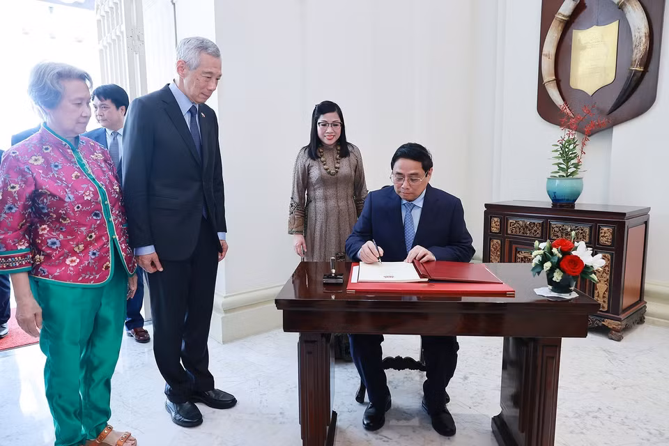 Thủ tướng Phạm Minh Chính ký sổ lưu niệm. (Ảnh: Dương Giang/TTXVN)