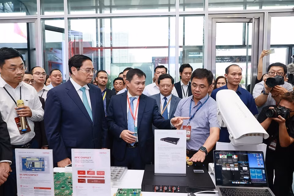Thủ tướng Phạm Minh Chính nghe giới thiệu về một số sản phẩm công nghệ. (Ảnh: Dương Giang/TTXVN)