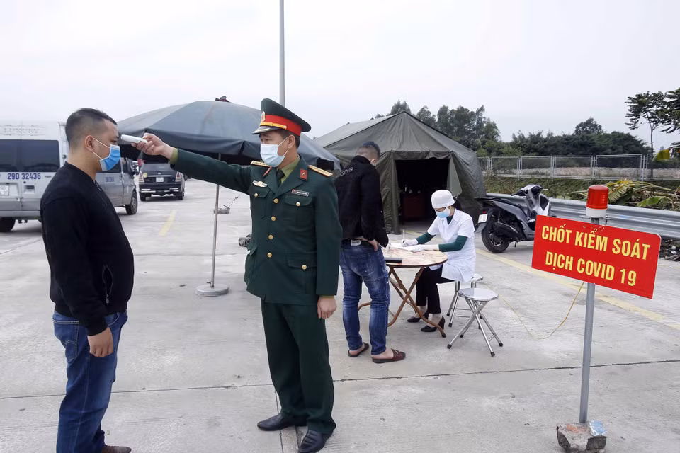 Lưc lượng liên ngành kiểm tra thân nhiệt với các hành khách muốn vào địa bàn tỉnh Hưng Yên. (Ảnh: Phạm Kiên/TTXVN)