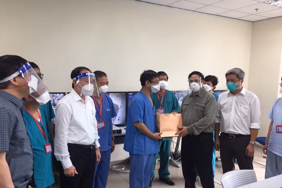 Thủ tướng Phạm Minh Chính tặng quà đội ngũ bác sỹ đang tham gia điều trị bệnh nhân COVID-19 tại bệnh viện dã chiến Hồi sức tích cực ở Bệnh viện quốc tế Becamex tỉnh Bình Dương. (Ảnh: TTXVN)