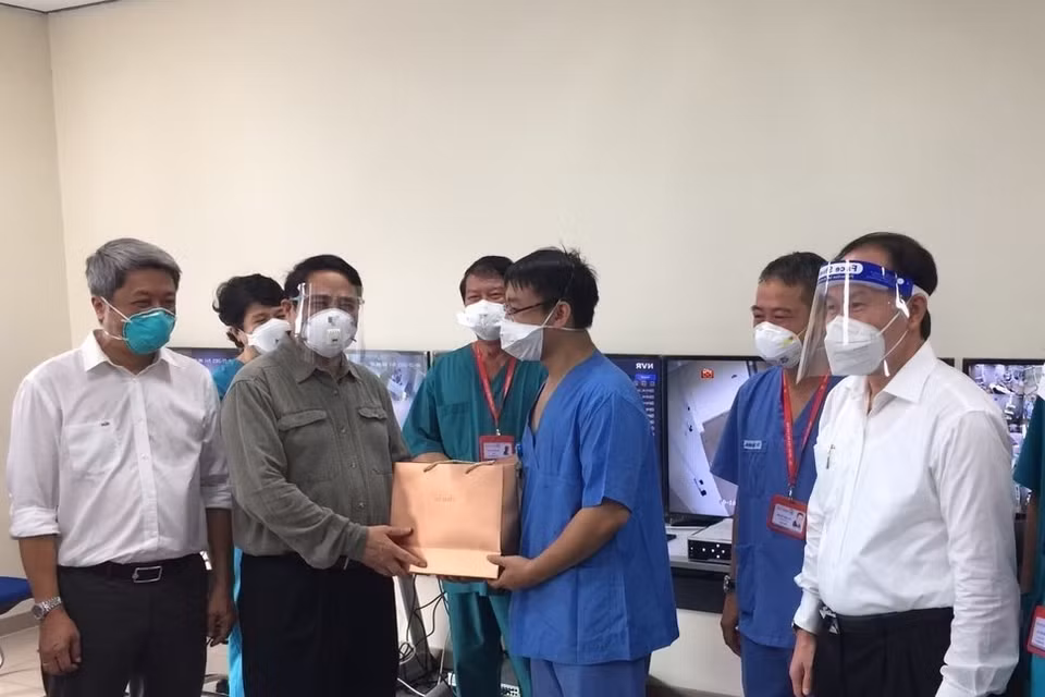 Hinh ảnh Thủ tướng Phạm Minh Chính thăm hỏi và tặng quà các bác sỹ đang tham gia điều trị bệnh nhân COVID-19 tại bệnh viện dã chiến Hồi sức tích cực Becamex tỉnh Bình Dương.( Ảnh: TTXVN)