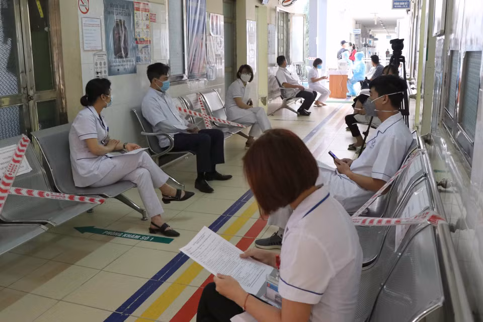 Sau quá trình khám, sàng lọc người chờ tiêm vaccine phòng COVID-19 được bố trí đảm bảo giãn cách ngoài hành lang. (Ảnh: Xuân Tiến/TTXVN)
