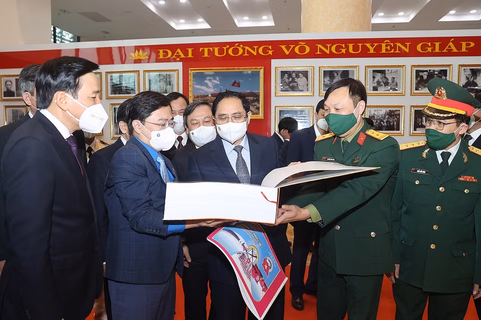 Thủ tướng Phạm Minh Chính và các đại biểu tham quan trưng bày ảnh và tư liệu, bài thi tìm hiểu về cuộc đời và sự nghiệp của Đại tướng Võ Nguyên Giáp. (Ảnh: Dương Giang/TTXVN)
