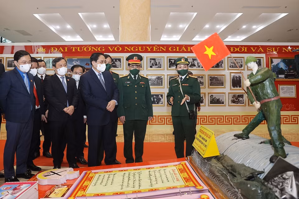 Thủ tướng Phạm Minh Chính và các đại biểu tham quan trưng bày ảnh và tư liệu về Đại tướng Võ Nguyên Giáp. (Ảnh: Dương Giang/TTXVN)