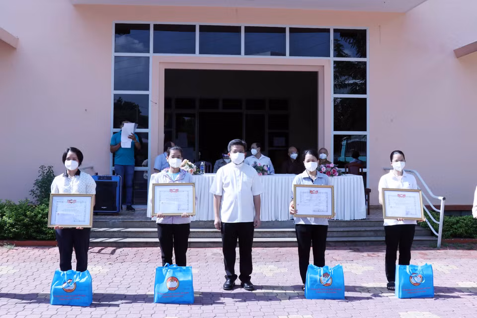 Linh mục Giuse Đào Nguyên Vũ, Chánh văn Phòng Hội đồng Giám mục Việt Nam trao giấy biểu dương tri ân các tình nguyện viên tôn giáo đã hoàn thành nhiệm vụ. (Ảnh: Xuân Khu/TTXVN)