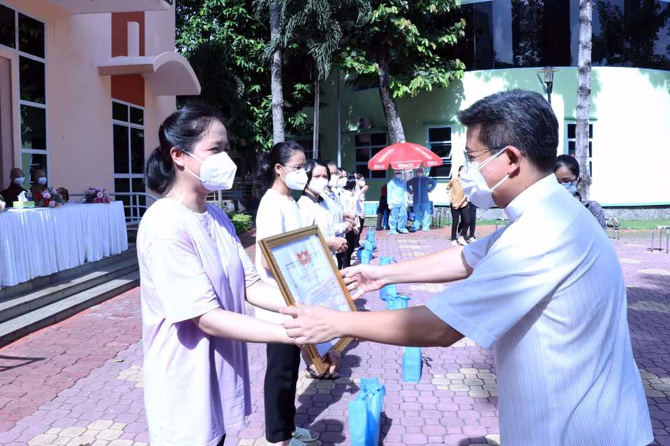 Linh mục Giuse Đào Nguyên Vũ, Chánh văn Phòng Hội đồng Giám mục Việt Nam trao giấy biểu dương tri ân các tình nguyện viên tôn giáo đã hoàn thành nhiệm vụ. (Ảnh: Xuân Khu/TTXVN)