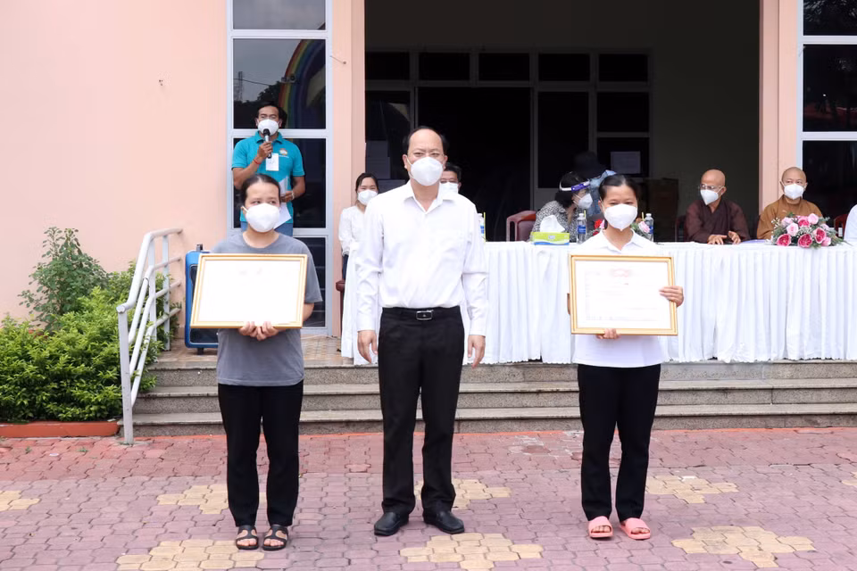 Phó Bí thư Thành ủy Thành phố Hồ Chí Minh Nguyễn Hồ Hải trao giấy biểu dương tri ân các tình nguyện viên đã hoàn thành nhiệm vụ. (Ảnh: Xuân Khu/TTXVN)