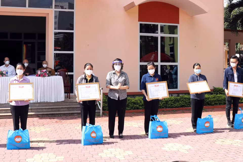 Bà Tô Thị Bích Châu, Chủ tịch Ủy ban Mặt trận Tổ quốc Việt Nam Thành phố trao giấy biểu dương, tặng quà tri ân các tình nguyện viên tôn giáo đã hoàn thành nhiệm vụ. (Ảnh: Xuân Khu/TTXVN)