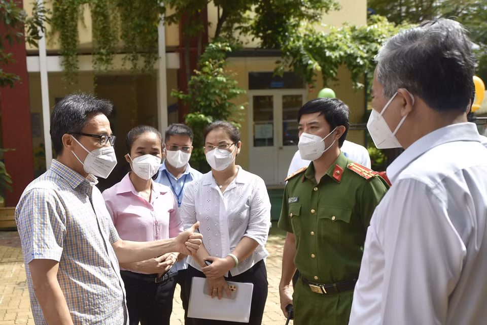 Phó Thủ tướng Vũ Đức Đam trao đổi với Lãnh đạo Quận 6 về công tác phòng, chống dịch COVID-19. (Ảnh: TTXVN phát)