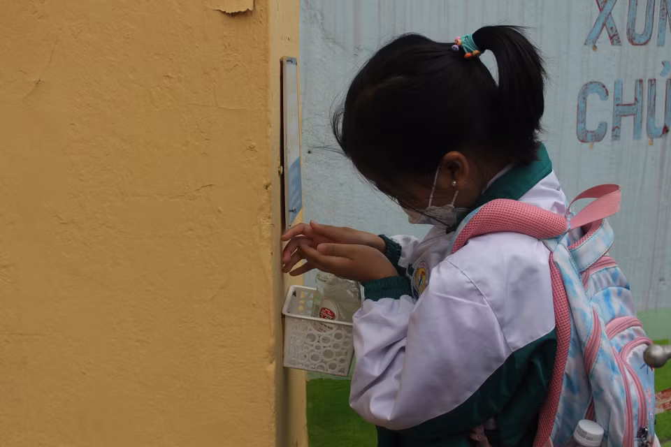 Ghi nhận tại trường tiểu học Phạm Tu (Thanh Trì) học sinh chủ động xịt khuẩn tại cổng trường. Khi có đông người, các em được điều phối hướng dẫn vào lớp xịt khuẩn, loa phát thanh cũng liên tục nhắc nhở các con nhanh chân vào lớp. (Ảnh: Minh Anh/Vietnam+)