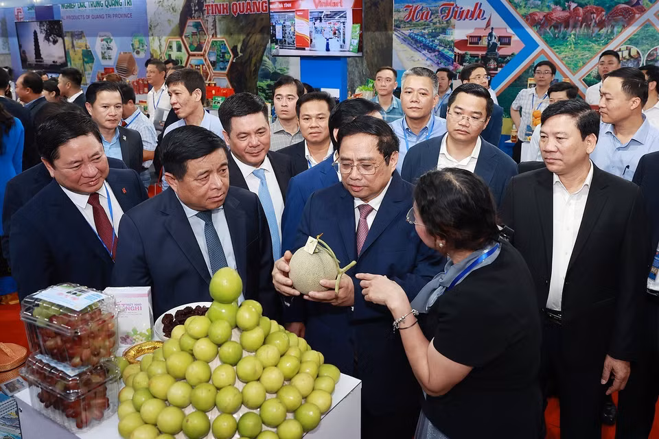 Thủ tướng Phạm Minh Chính nghe giới thiệu về sản phẩm của các tỉnh Bắc Trung Bộ và duyên hải Trung Bộ. (Ảnh: Dương Giang/TTXVN)