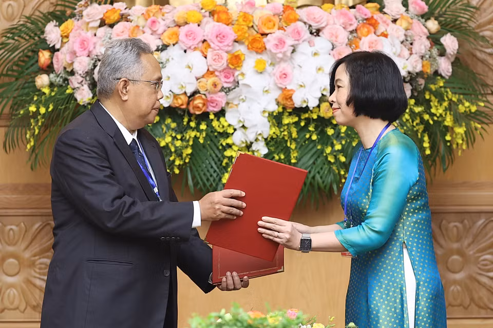 Tổng Giám đốc Thông tấn xã Việt Nam Vũ Việt Trang và Tổng biên tập Hãng thông tấn quốc gia Malaysia (BERNAMA) Khairdzir Md Yunus trao đổi Thỏa thuận hợp tác nghiệp vụ giữa Thông tấn xã Việt Nam và Hãng thông tấn quốc gia Malaysia. (Ảnh: Dương Giang/TTXVN)
