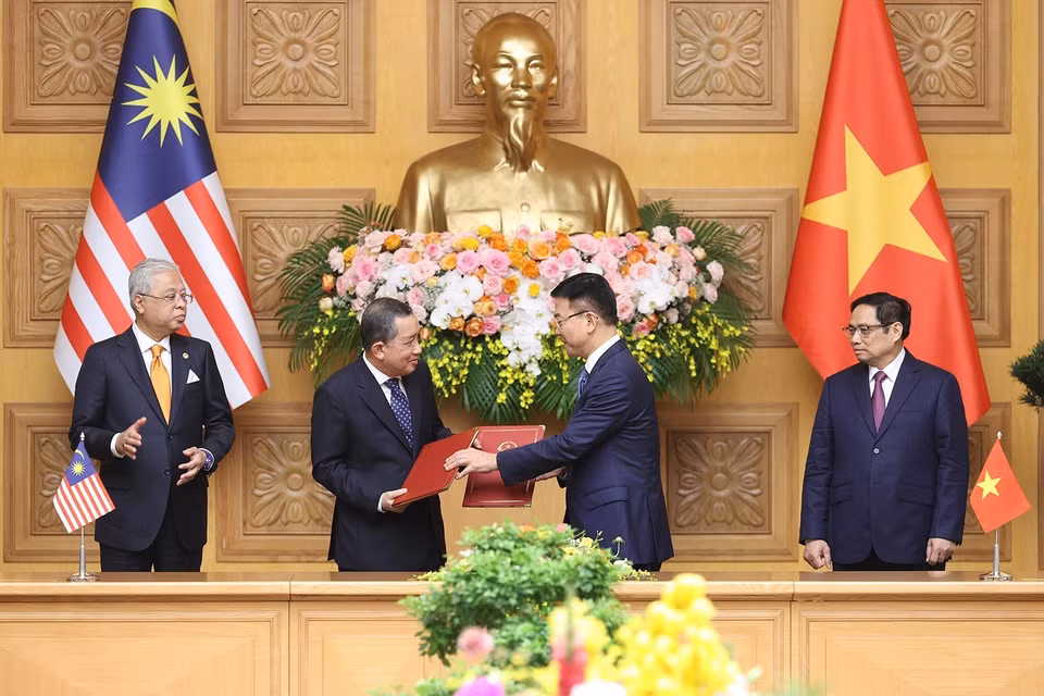 Bộ trưởng Bộ Tư pháp Lê Thành Long và Tổng Chưởng lý Malaysia Tan Sri Idrus Bin Harun trao đổi Bản ghi nhớ giữa Chính phủ Việt Nam và Chính phủ Malaysia về hợp tác pháp luật. (Ảnh: Dương Giang/TTXVN)