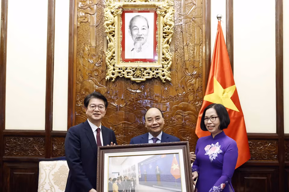 Tổng Giám đốc TTXVN Vũ Việt Trang tặng Chủ tịch nước Nguyễn Xuân Phúc bức ảnh các đại biểu hai nước khai trương và tham quan Triển lãm "30 năm Hợp tác Việt Nam-Hàn Quốc" sáng 14/12 tại Hà Nội. (Ảnh: Thống Nhất/TTXVN)