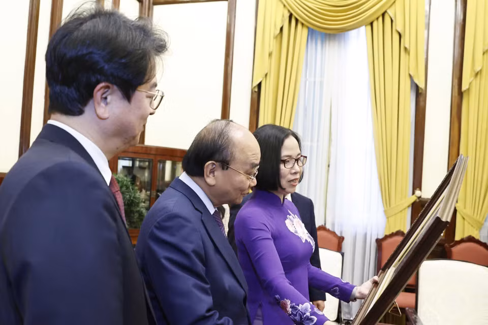 Tổng Giám đốc TTXVN Vũ Việt Trang tặng Chủ tịch nước Nguyễn Xuân Phúc bức ảnh các đại biểu hai nước khai trương và tham quan Triển lãm "30 năm Hợp tác Việt Nam-Hàn Quốc" sáng 14/12 tại Hà Nội. (Ảnh: Thống Nhất/TTXVN)