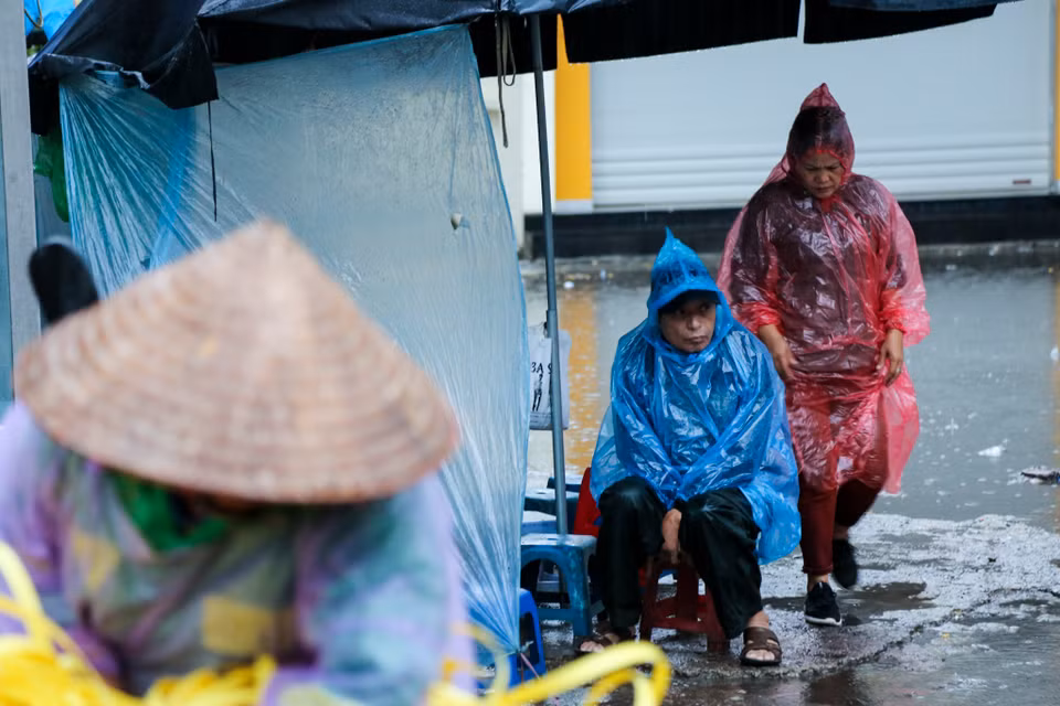 Mặc dù nhiệt độ này chưa phải quá thấp nhưng là đợt rét đầu mùa và mưa rải rác khiến người đi đường phải co ro vì lạnh. (Ảnh: Minh Sơn/Vietnam+)