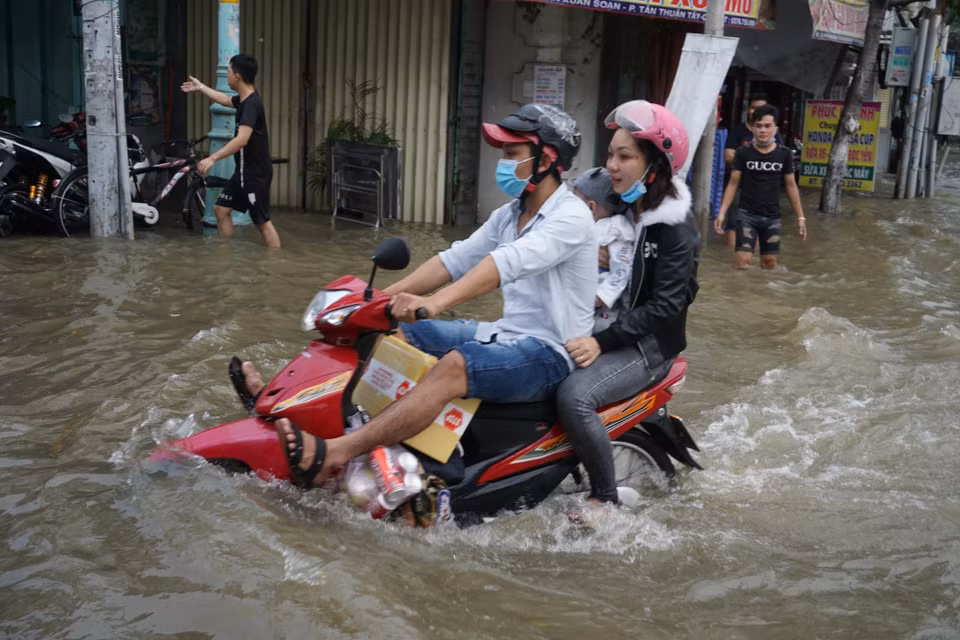 Người dân di chuyển khó khăn trong mùa triều cường. (Ảnh: Trần Xuân Tình/TTXVN)