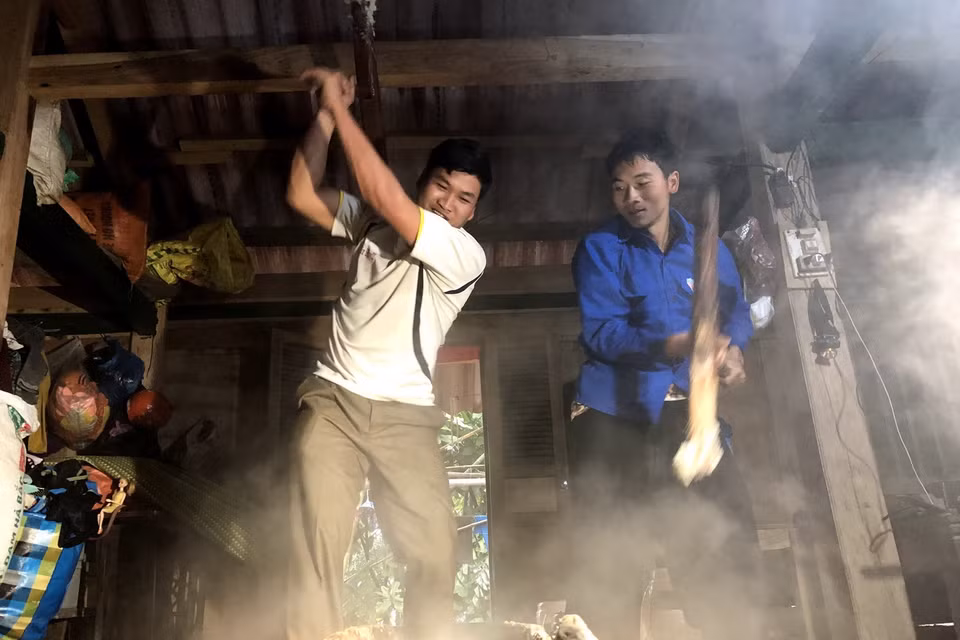 Các thanh niên tham gia giã bánh dày trong ngày tết người Mông. (Ảnh: Hữu Quyết/TTXVN)