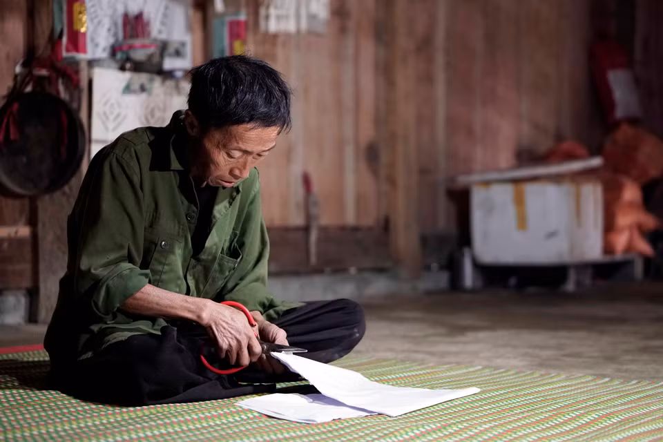 Nghi thức cắt giấy để dán lên các công cụ lao động của người Mông. Các cô gái người Mông ở xã Hồng Ngài, huyện Bắc Yên tham gia trò chơi ném pa pao. (Ảnh: Hữu Quyết/TTXVN)