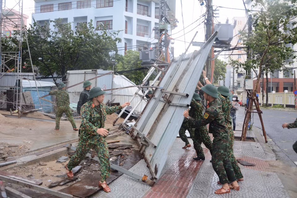 Lực lượng bộ đội hỗ trợ dọn dẹp vệ sinh đường phố sau khi bão đổ bộ. (Ảnh: Văn Dũng/TTXVN)