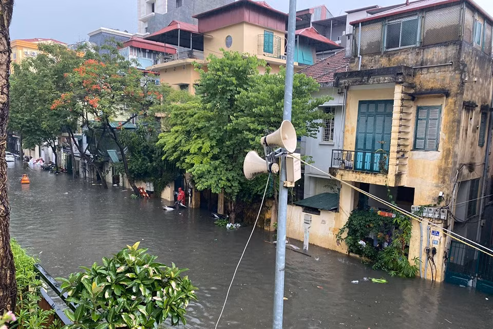 Nước mưa cùng nước thải đục ngầu tràn vào nhiều nhà dân ven đường. (Ảnh: Vietnam+)