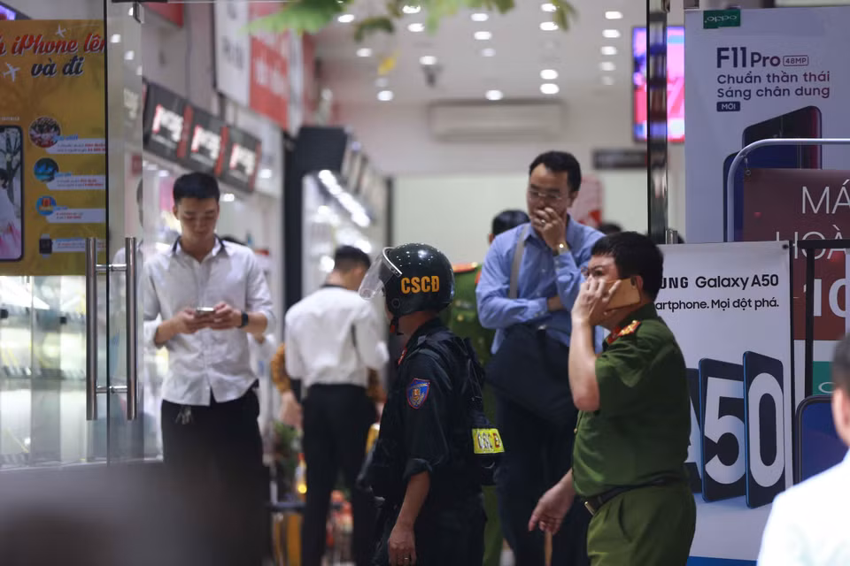 Cảnh sát kiểm tra, khám xét tại cửa hàng điện thoại Nhật Cường mobile ở 33 Lý Quốc Sư, Hà Nội. (Ảnh: Doãn Tấn/TTXVN)