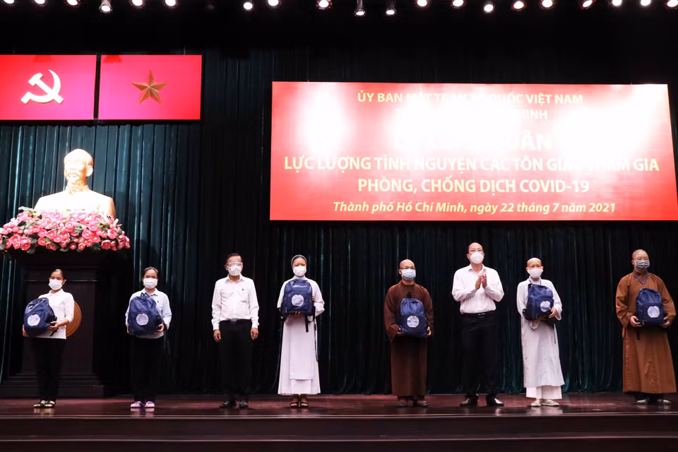 Sáng 22/7/2021, tại Hội trường Thành ủy Thành phố Hồ Chí Minh, Ủy ban Mặt trận Tổ quốc Việt Nam Thành phố Hồ Chí Minh trang trọng tổ chức Lễ xuất quân lực lượng tình nguyện tôn giáo đợt đầu tiên tham gia hỗ trợ các bệnh viện dã chiến, bệnh viện hồi sức COVID-19 trên địa bàn Thành phố. Trong ảnh: Lãnh đạo Thành phố trao tượng trương ba lô, vật dụng cá nhân cho đại diện các tình nguyện viên tôn giáo. (Ảnh: Xuân Khu/TTXVN)