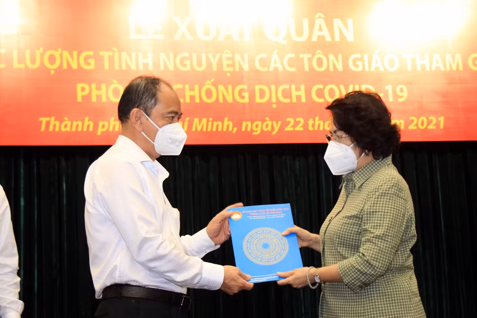 Bà Tô Thị Bích Châu, Chủ tịch Ủy ban Mặt trận Tổ quốc Việt Nam Thành phố Hồ Chí Minh trao danh sách tình nguyện viên tôn giáo cho đại diện lãnh đạo Sở Y tế Thành phố Hồ Chí Minh. (Ảnh: Xuân Khu/TTXVN)