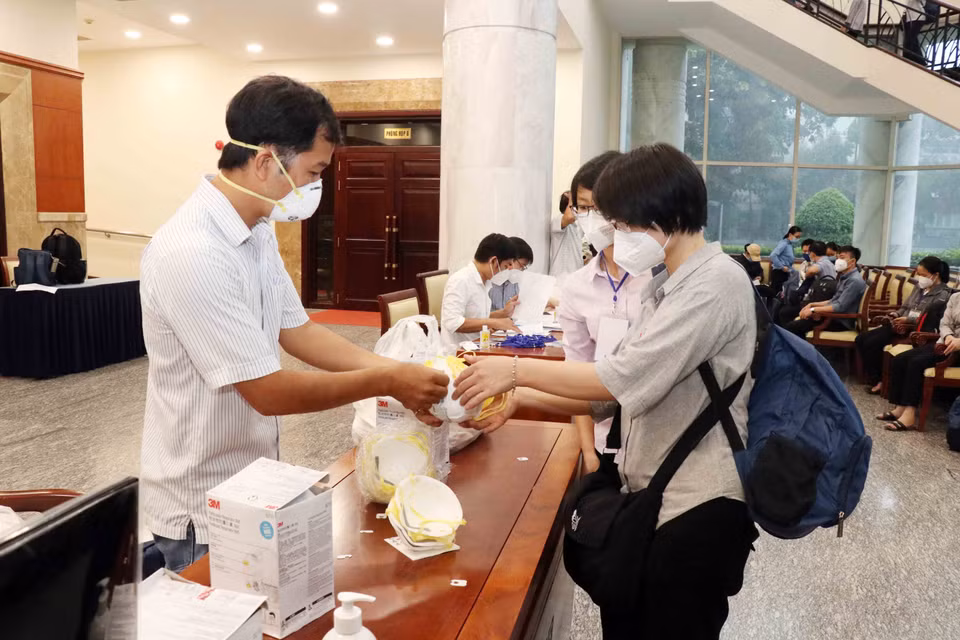 Các tình nguyện viên nhận khẩu trang N95 đảm bảo chống lây nhiễm trong môi trường tại các bệnh viện điều trị COVID-19. (Ảnh: Xuân Khu/TTXVN)