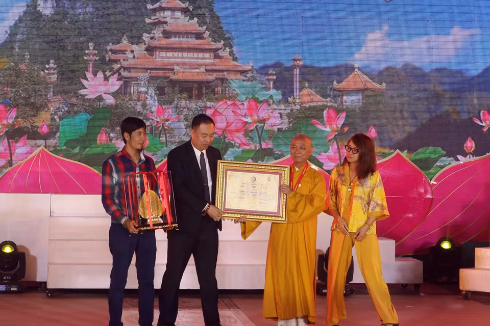 Ban Tổ chức trao chứng nhận kỷ lục Việt Nam cho độc bản Lá Bồ Đề lớn nhất được mạ vàng 24k tại Lễ hội Quán Thế Âm Ngũ Hành Sơn. (Ảnh: Trần Lê Lâm/TTXVN)