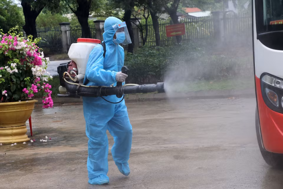 Nhân viên y tế khử trùng các phương tiện ra vào khu vực bệnh viện dã chiến. (Ảnh: Quốc Dũng/TTXVN)