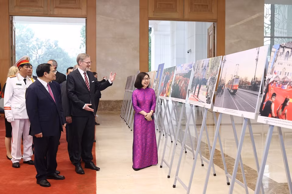 Phó Tổng Giám đốc Thông tấn xã Việt Nam Đoàn Thị Tuyết Nhung giới thiệu trưng bày ảnh với hai Thủ tướng. (Ảnh: Dương Giang/TTXVN)