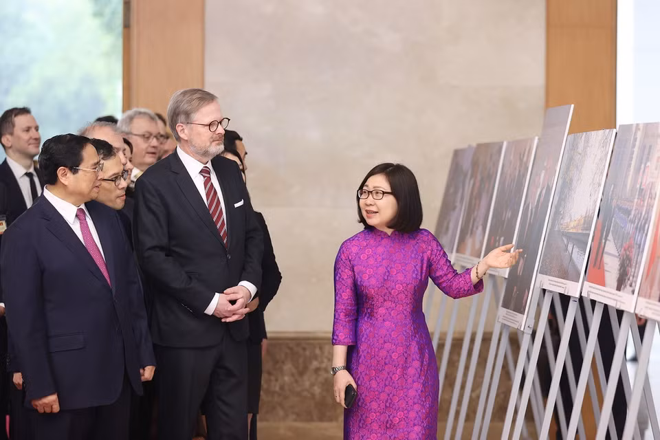 Phó Tổng Giám đốc Thông tấn xã Việt Nam Đoàn Thị Tuyết Nhung giới thiệu trưng bày ảnh với hai Thủ tướng. (Ảnh: Dương Giang/TTXVN)