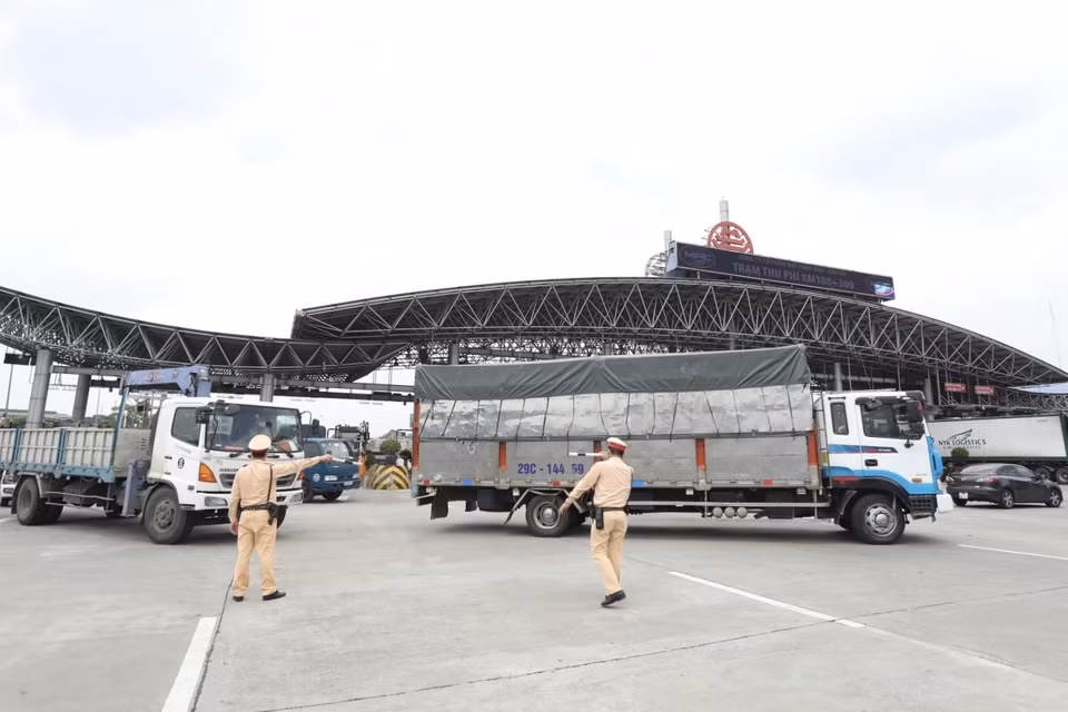 Lực lượng chức năng hướng dẫn các phương tiện quay đầu tại trạm thu phí Pháp Vân-Cầu Giẽ khi thực hiện Chỉ thị 17 của UBND thành phố. (Ảnh: Minh Quyết/TTXVN)