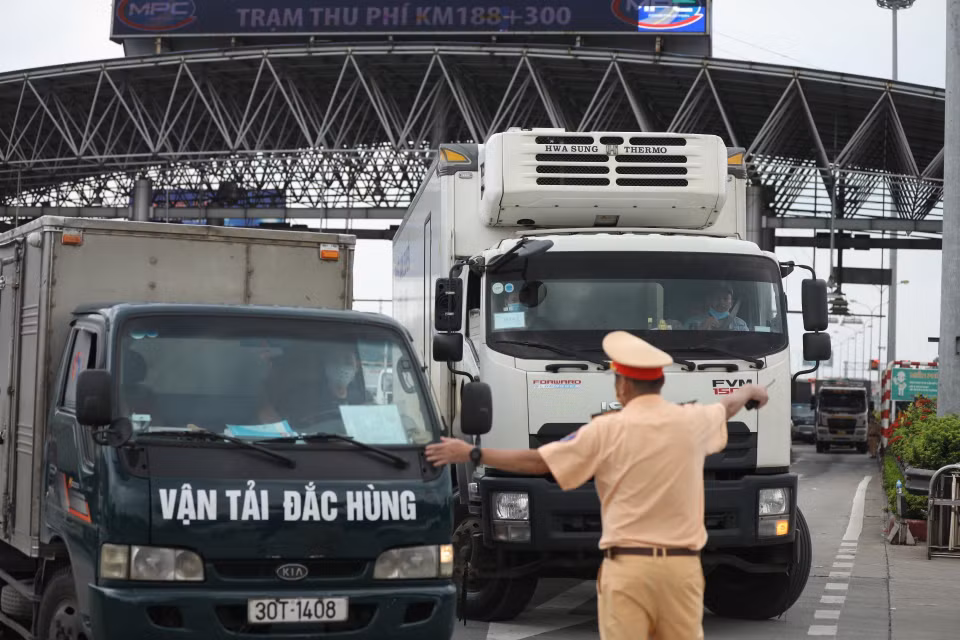 Lực lượng chức năng hướng dẫn các phương tiện quay đầu tại trạm thu phí Pháp Vân-Cầu Giẽ khi thực hiện Chỉ thị 17 của UBND thành phố. (Ảnh: Minh Quyết/TTXVN)