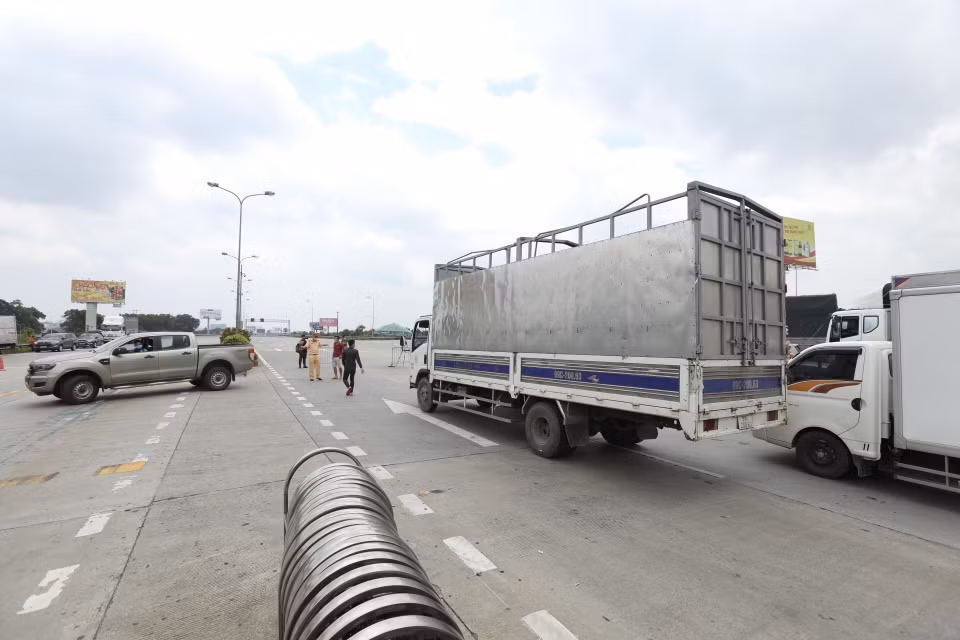 Lực lượng chức năng hướng dẫn các phương tiện quay đầu tại trạm thu phí Pháp Vân-Cầu Giẽ khi thực hiện Chỉ thị 17 của UBND thành phố. (Ảnh: Minh Quyết/TTXVN)