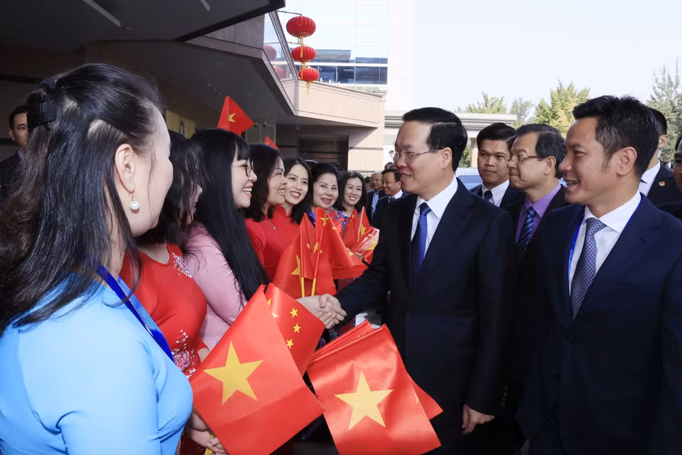Cán bộ, nhân viên Đại sứ quán và cộng đồng người Việt Nam đón Chủ tịch nước Võ Văn Thưởng tại Sân bay Quốc tế Bắc Kinh. (Ảnh: Thống Nhất/TTXVN)